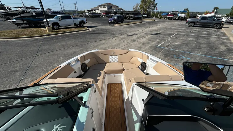 Slide: The Image of 2025 MasterCraft XT24 boat interior with tan seating in a parking lot. - 19