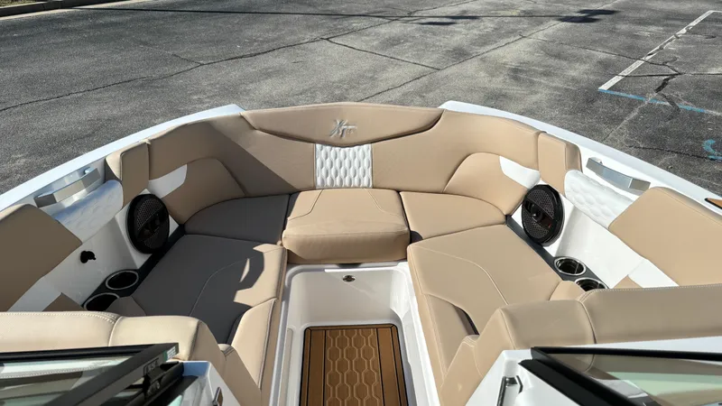 Slide: The Image of 2025 MasterCraft XT24 boat interior with beige seating and cup holders. - 20