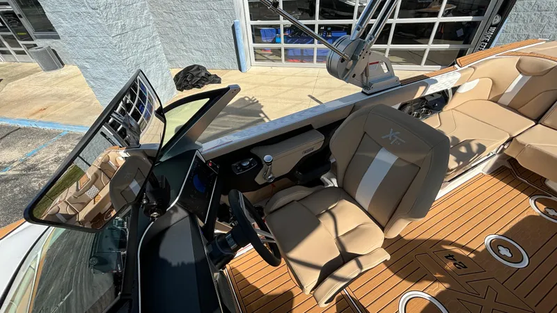 Slide: The Image of 2025 MasterCraft XT24 boat interior with tan seating and modern dashboard. - 25