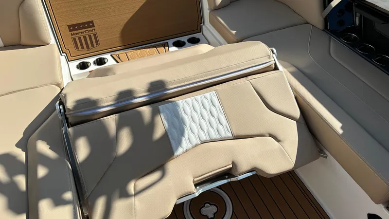 Slide: The Image of 2025 MasterCraft XT24 boat interior with beige seating and wood accents. - 29