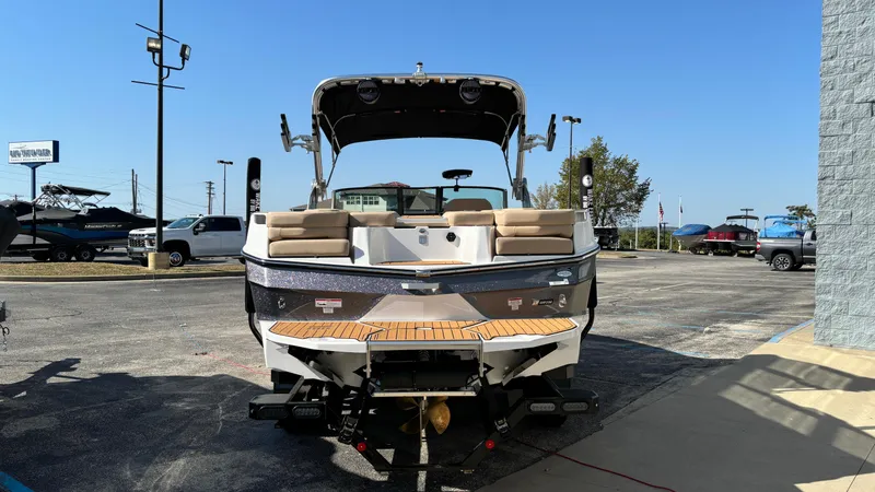 Slide: The Image of 2025 MasterCraft XT24 boat, rear view, parked outdoors on a sunny day. - 3