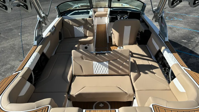Slide: The Image of 2025 MasterCraft XT24 boat interior with beige seating and modern design. - 32