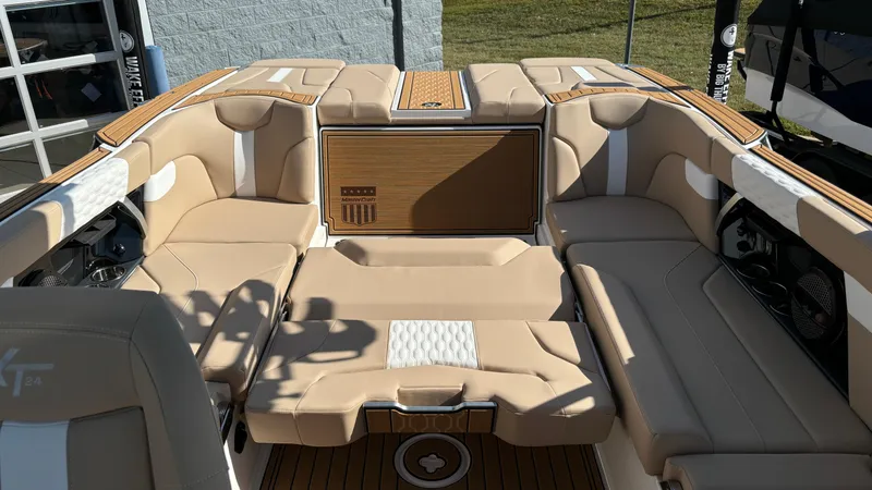 Slide: The Image of 2025 MasterCraft XT24 boat interior with beige seating and wood accents. - 34