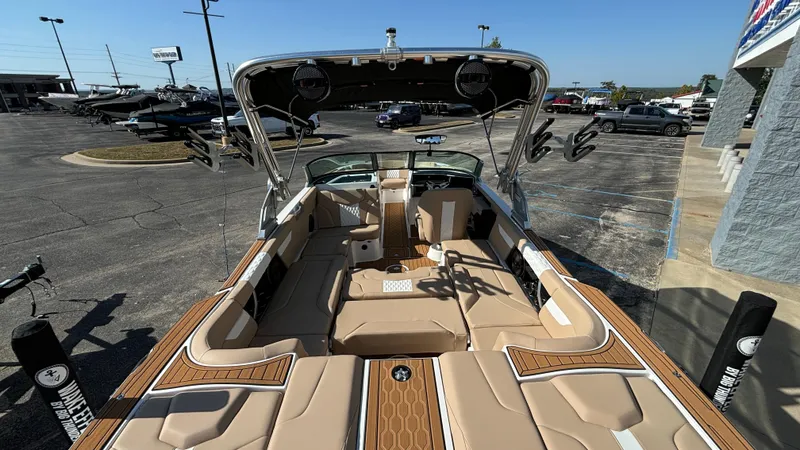 Slide: The Image of 2025 MasterCraft XT24 boat interior with tan seating and wood accents. - 37