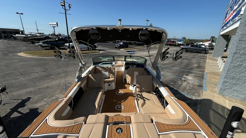 Slide: The Image of 2025 MasterCraft XT24 boat with spacious seating and sleek design in a parking lot. - 5
