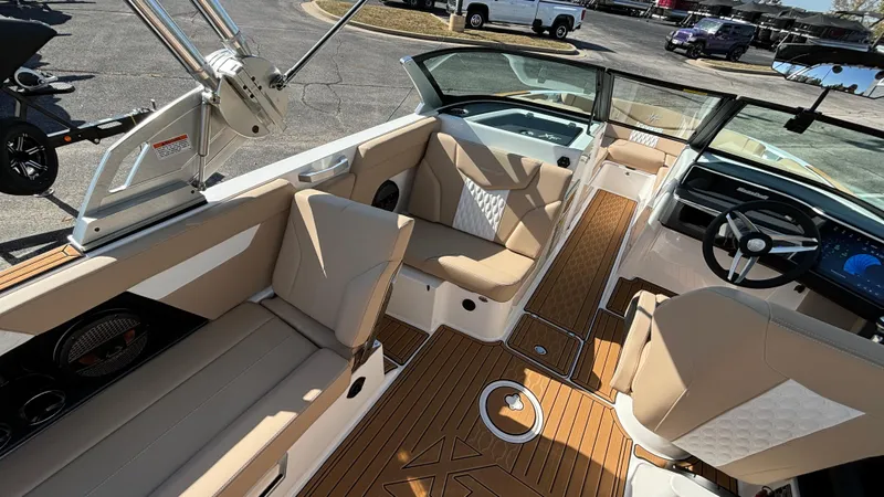 Slide: The Image of 2025 MasterCraft XT24 boat interior with beige seating and modern dashboard. - 9