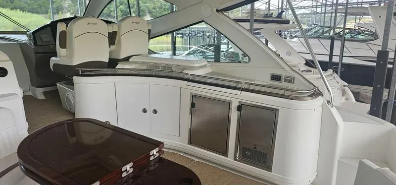 Slide: The Image of 2011 Cruisers Yachts 540 interior with seating and cabinetry in a marina setting. - 11