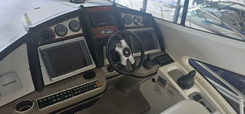 Slide: The Image of Control panel of a 2011 Cruisers Yachts 540 with navigation screens and steering wheel. - 6