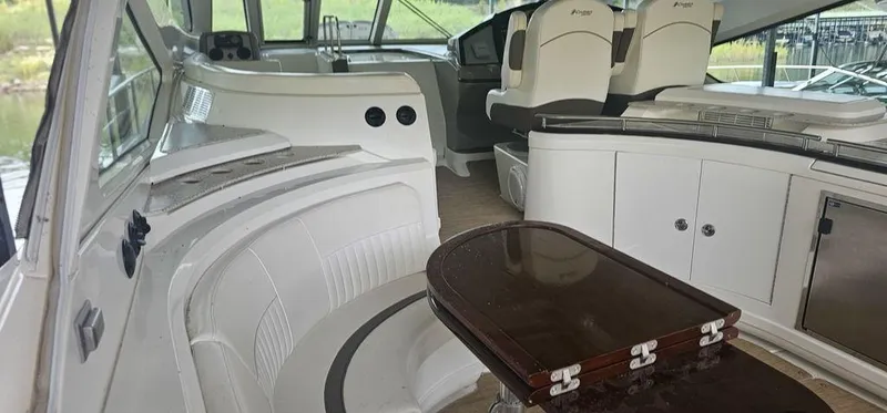 Slide: The Image of Interior of 2011 Cruisers Yachts 540, featuring elegant seating and a polished wooden table. - 13