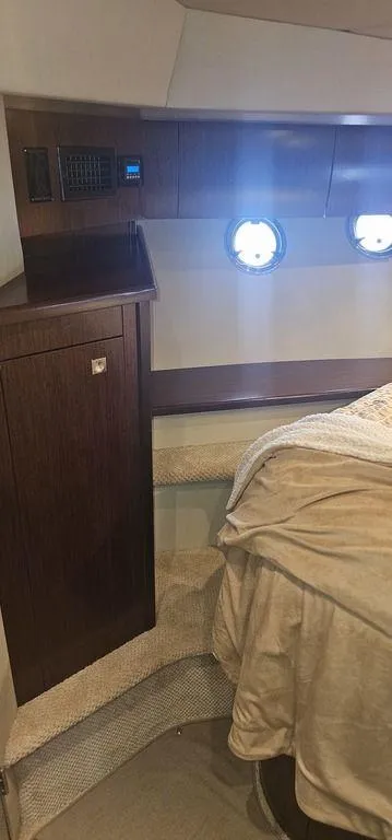 Slide: The Image of 2011 Cruisers Yachts 540 interior cabin with portholes and wooden cabinetry. - 17