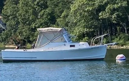 Slide: The Image of 1984 SISU Cuddy boat on calm water near a forested shoreline. - 4