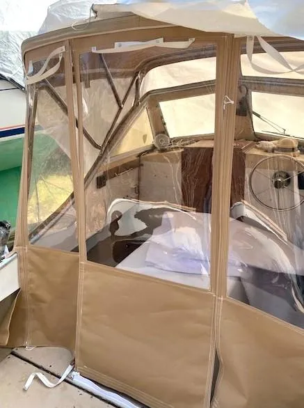 Slide: The Image of 1984 SISU Cuddy boat with tan canvas enclosure and clear windows. - 5