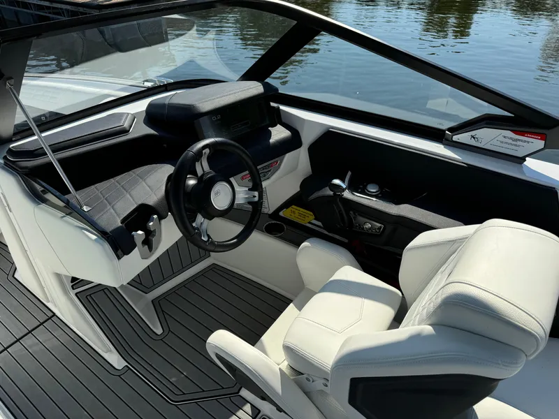 Slide: The Image of 2024 Nautique G23 Coastal Edition boat interior with sleek steering and modern dashboard. - 12