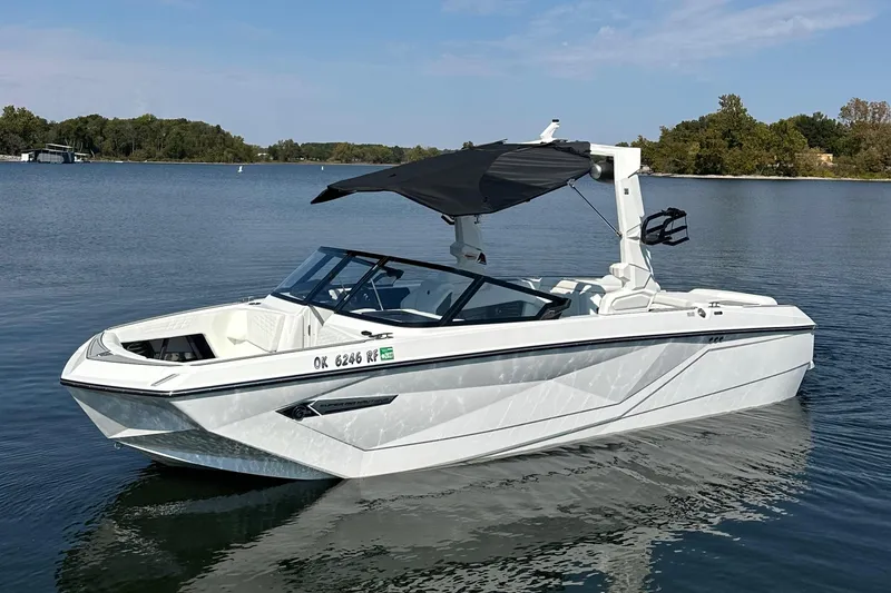 Slide: The Image of 2024 Nautique G23 Coastal Edition boat on a serene lake. - 4