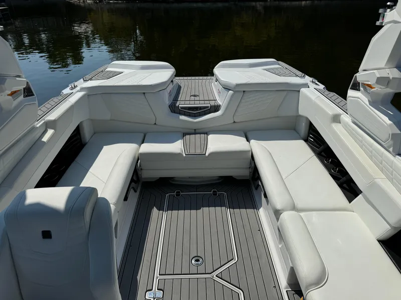 Slide: The Image of 2024 Nautique G23 Coastal Edition boat interior with white seating and gray flooring. - 6