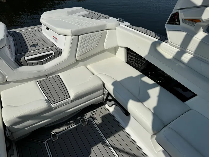 Slide: The Image of 2024 Nautique G23 Coastal Edition interior with white seating and gray flooring. - 7