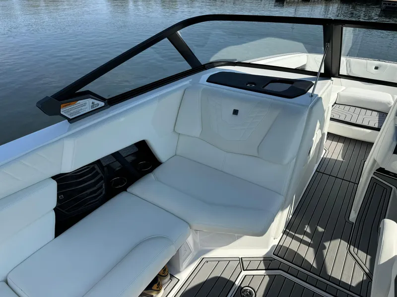Slide: The Image of 2024 Nautique G23 Coastal Edition boat interior with white seating and sleek design. - 9
