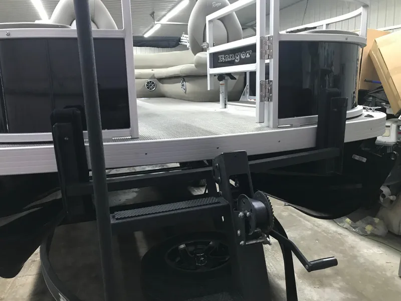 Slide: The Image of 2025 Ranger Reata 200F pontoon boat in a garage setting. - 12