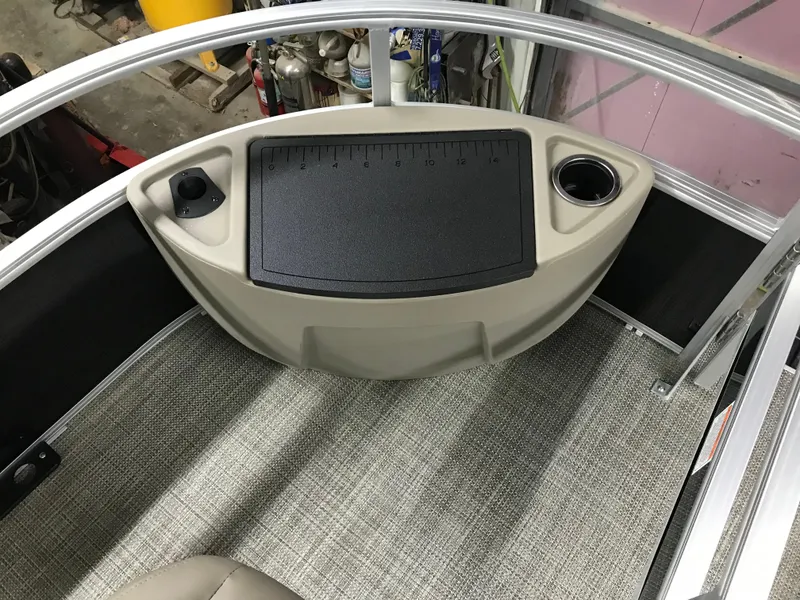 Slide: The Image of 2025 Ranger Reata 200F boat interior with beige seating and steering console. - 16