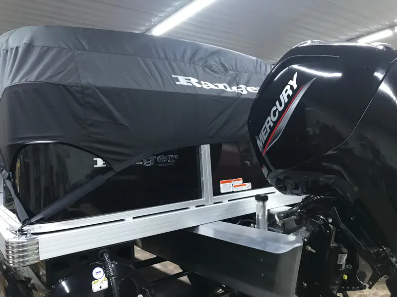 Slide: The Image of 2025 Ranger Reata 200F pontoon boat with black cover in a garage setting. - 34