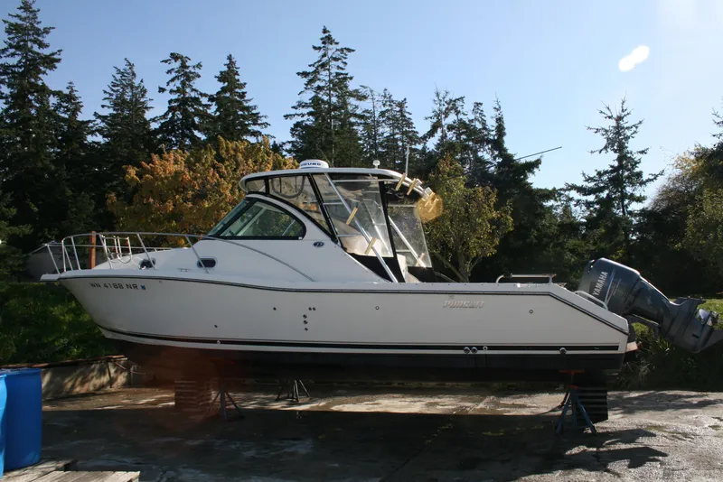The Image of 2005 Pursuit 3370 Offshore boat on stands, surrounded by trees. - 0