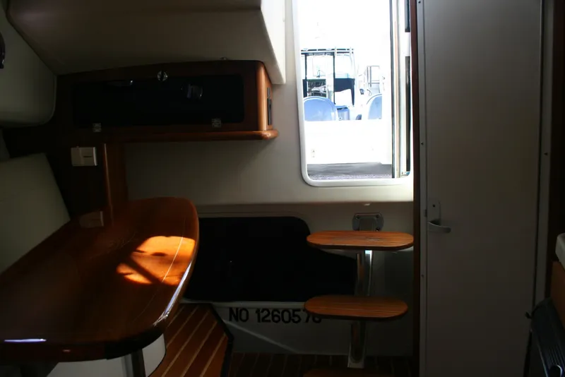 Slide: The Image of Interior of 2005 Pursuit 3370 Offshore boat with wooden table and steps. - 17