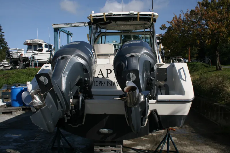 Slide: The Image of 2005 Pursuit 3370 Offshore boat with dual outboard motors on a trailer. - 19