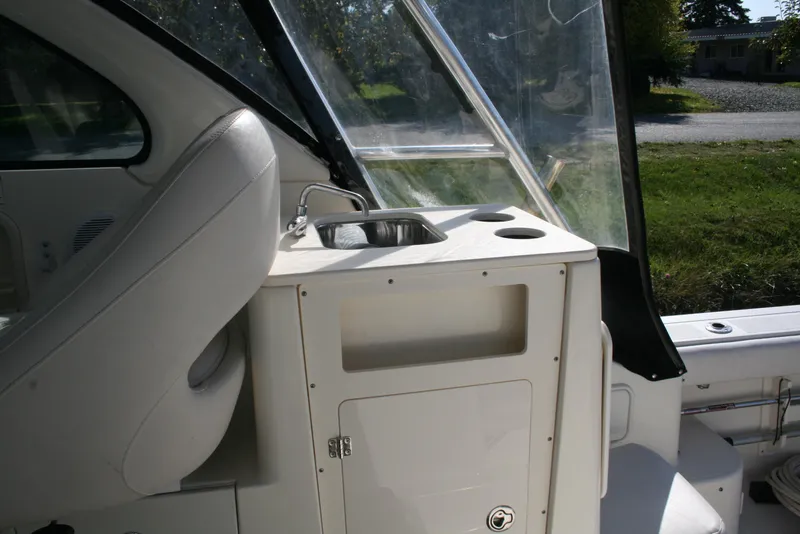 Slide: The Image of 2005 Pursuit 3370 Offshore boat interior with sink and seating area. - 3