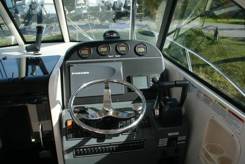 Slide: The Image of 2005 Pursuit 3370 Offshore boat helm with steering wheel and navigation instruments. - 7
