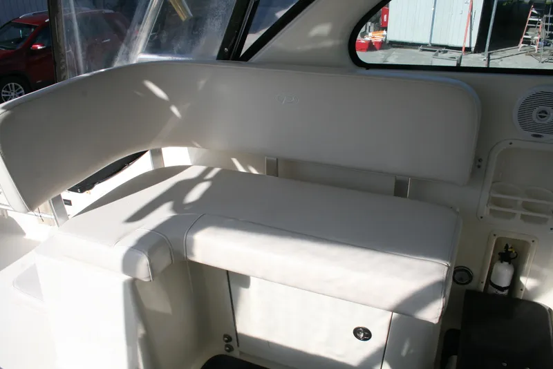 Slide: The Image of 2005 Pursuit 3370 Offshore boat interior seating area with white upholstery. - 9