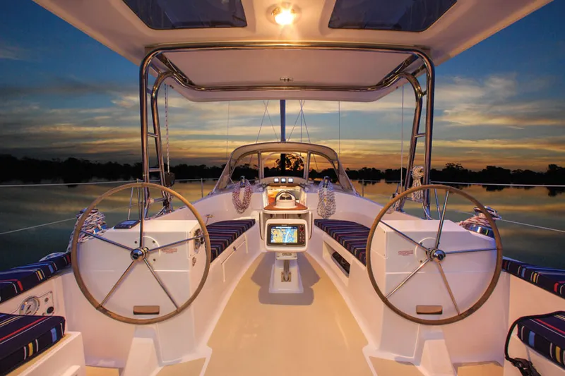 Slide: The Image of Interior of 2014 Marlow Hunter 40 sailboat at sunset, featuring dual steering wheels. - 11