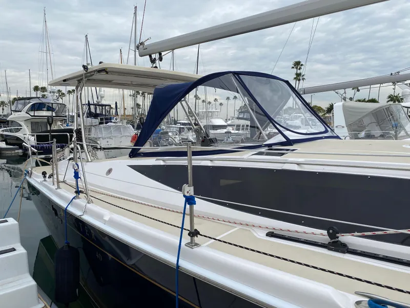 Slide: The Image of 2014 Marlow Hunter 40 sailboat docked in marina, featuring sleek design and blue canopy. - 17