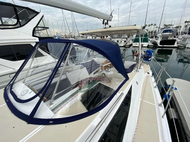 Slide: The Image of 2014 Marlow-Hunter 40 sailboat docked in marina, featuring blue canopy and sleek design. - 27