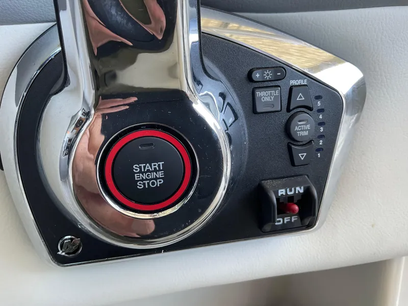 Slide: The Image of 2024 Chaparral 23 SSi boat control panel with start/stop button and trim controls. - 1