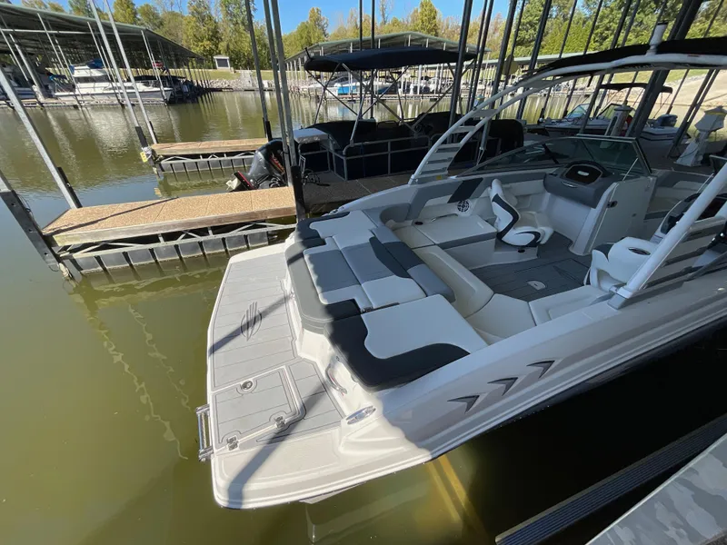 Slide: The Image of 2024 Chaparral 23 SSi boat docked at marina, featuring spacious seating and sleek design. - 6