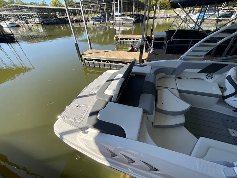 Slide: The Image of 2024 Chaparral 23 SSi boat docked at marina, featuring sleek seating and modern design. - 7