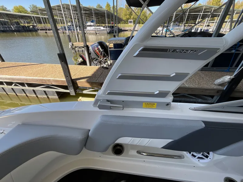 Slide: The Image of 2024 Chaparral 23 SSi boat interior at marina dock, featuring sleek seating and storage. - 8