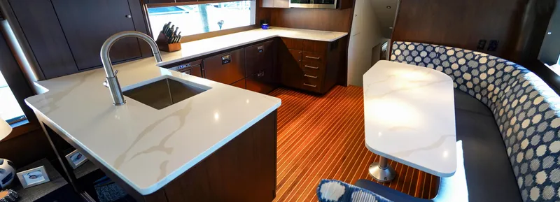 Slide: The Image of Luxurious interior of a 1999 Hatteras 70 Convertible yacht with modern kitchen and seating area. - 18