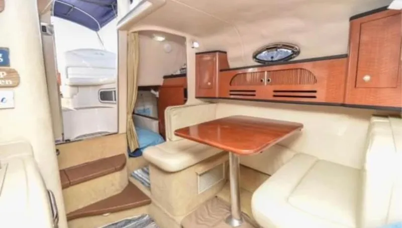 Slide: The Image of Interior of 2005 Sea Ray 280 DA boat with dining area and wooden cabinetry. - 11