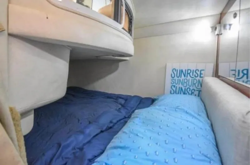 Slide: The Image of Interior cabin of 2005 Sea Ray 280 DA with blue bedding and wall art. - 12