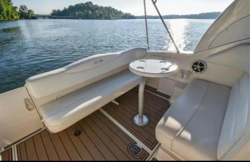 Slide: The Image of 2005 Sea Ray 280 DA boat interior with seating and table on a sunny lake. - 8
