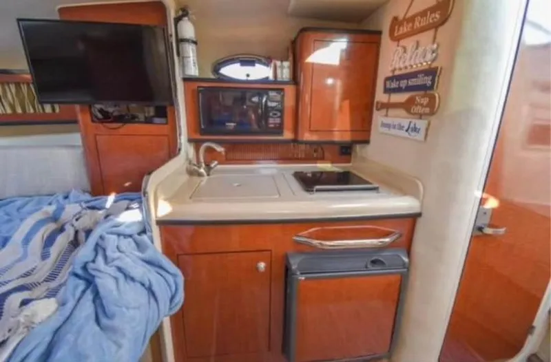 Slide: The Image of Interior of 2005 Sea Ray 280 DA boat with kitchenette and cozy sleeping area. - 9