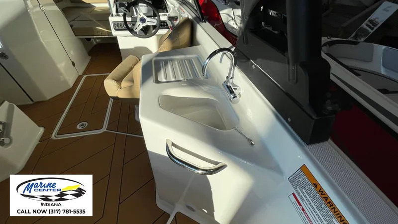 Slide: The Image of Interior of 2025 Bayliner D22I boat with sink and steering wheel, Marine Center contact info. - 10