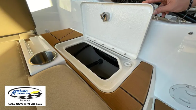 Slide: The Image of 2025 Bayliner D22I boat storage compartment with cup holder, Marine Center Indiana contact info. - 11