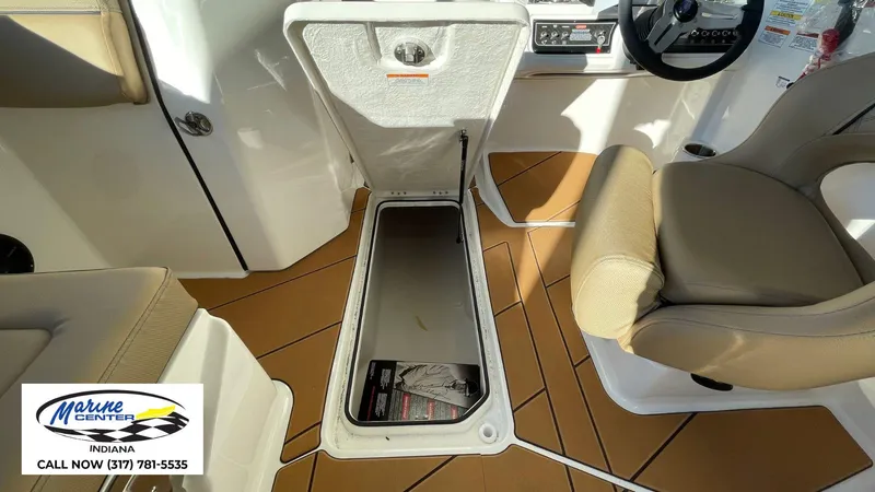 Slide: The Image of 2025 Bayliner D22I boat interior with storage compartment and seating, Marine Center Indiana contact info. - 13