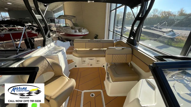 Slide: The Image of 2025 Bayliner D22I boat interior with tan seating, displayed at Marine Center Indiana. - 15