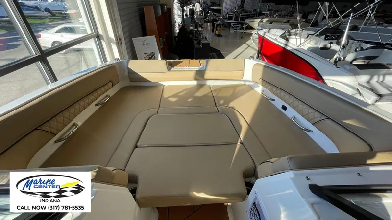 Slide: The Image of 2025 Bayliner D22I boat interior with beige seating at Marine Center Indiana showroom. - 9