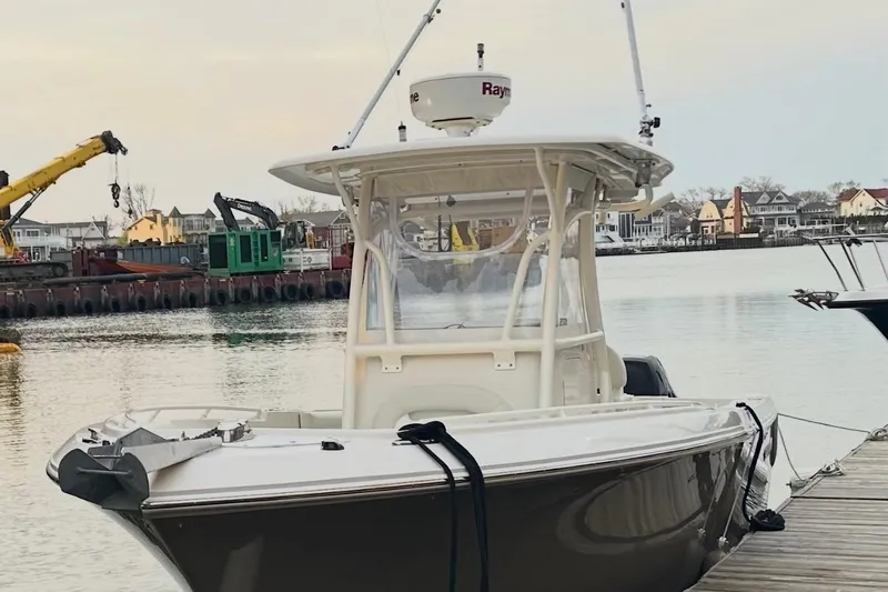 The Image of 2014 Sailfish 270 CC boat docked in a marina with cranes in the background. - 0