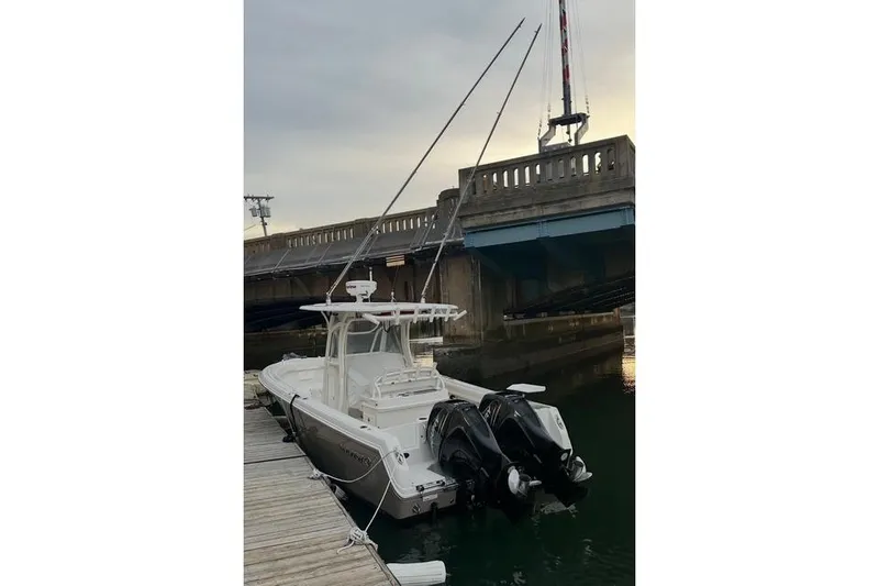 Slide: The Image of 2014 Sailfish 270 CC boat docked near a bridge at sunset. - 3