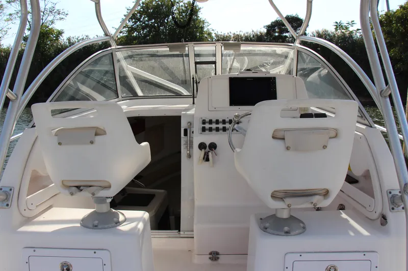 Slide: The Image of 2005 Pro-Line 29 Express boat cockpit with dual white seats and control panel. - 12